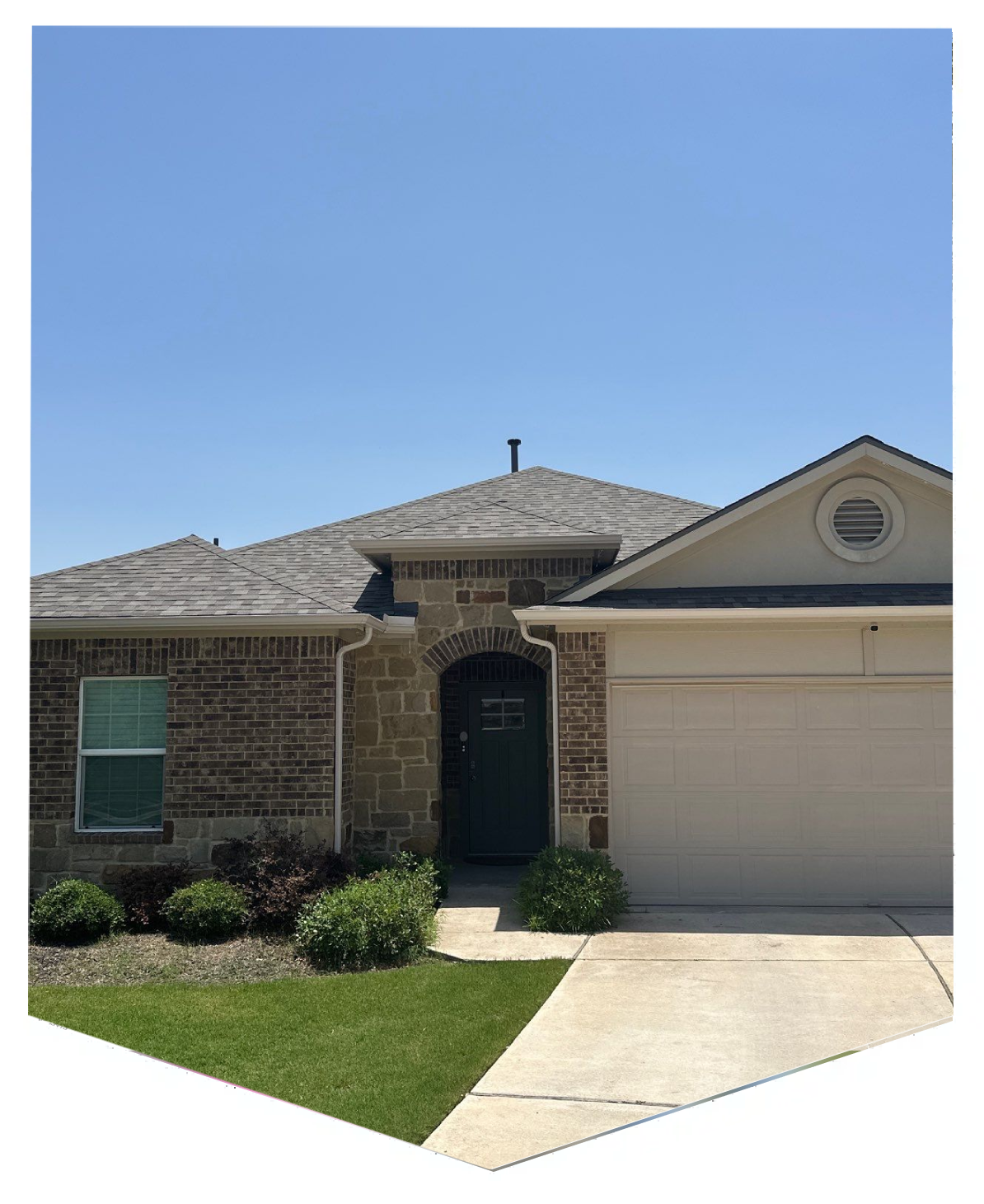 A single-story brick house with a two-car garage and a small front yard.