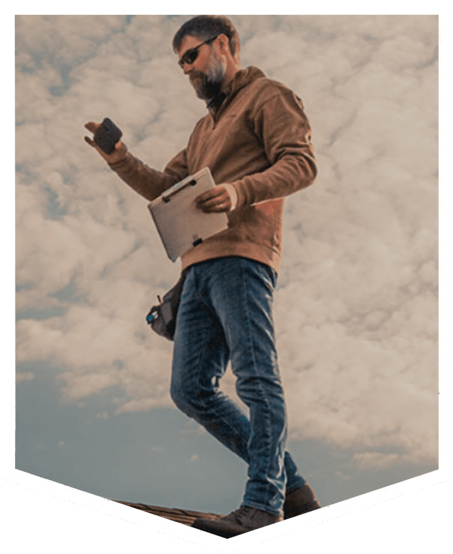 A man in casual clothes walking outdoors under a cloudy sky.
